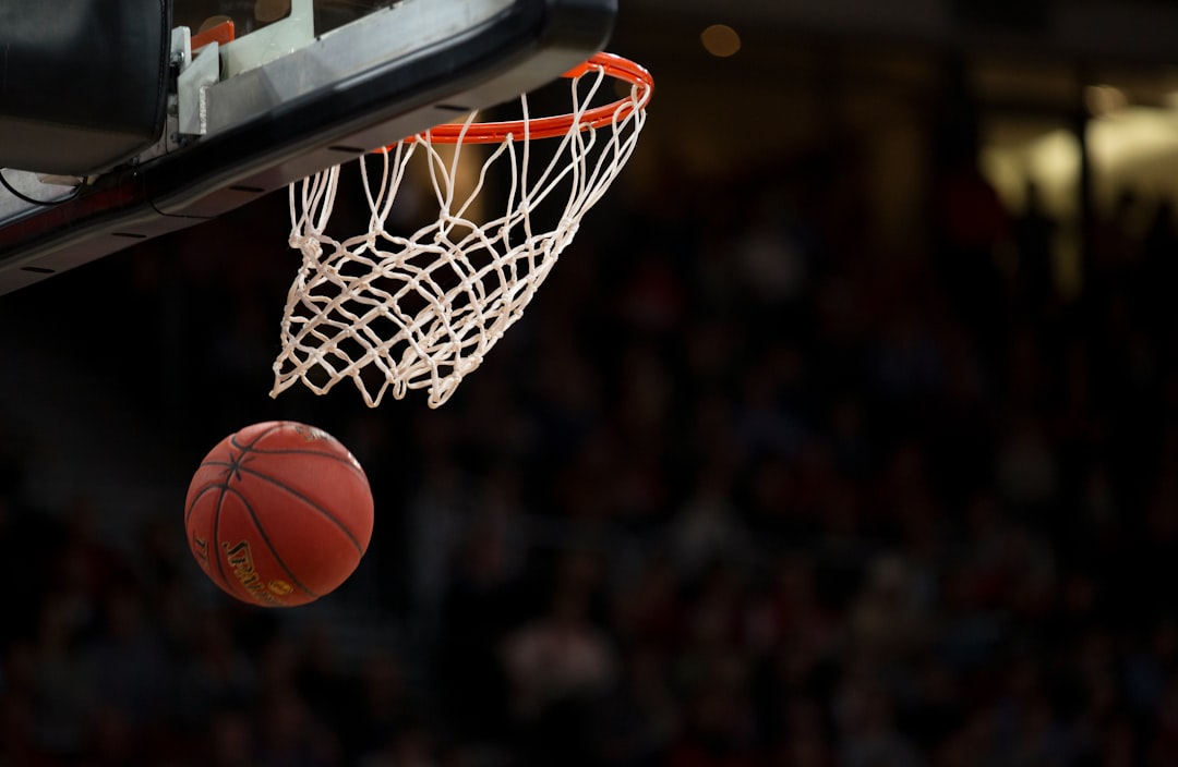 Basketball beneath a hoop on an indoor court; generic basketball image, not an NBA game photo.