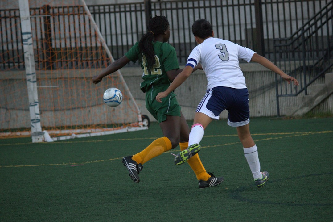 Soccer players on a grass field illustrating cleat and surface compatibility