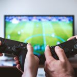 Generic video game controllers representing soccer video games; not an EA Sports FC or eFootball game screenshot.