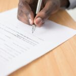 Person signing a document used to represent professional sports contracts and salary caps