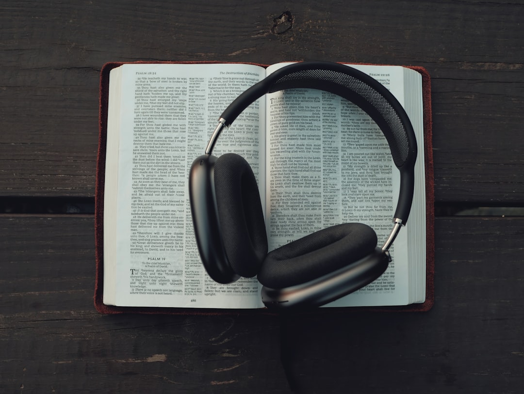 Headphones resting on an open book for sports audiobooks