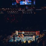 Two boxers sparring in a crowded arena