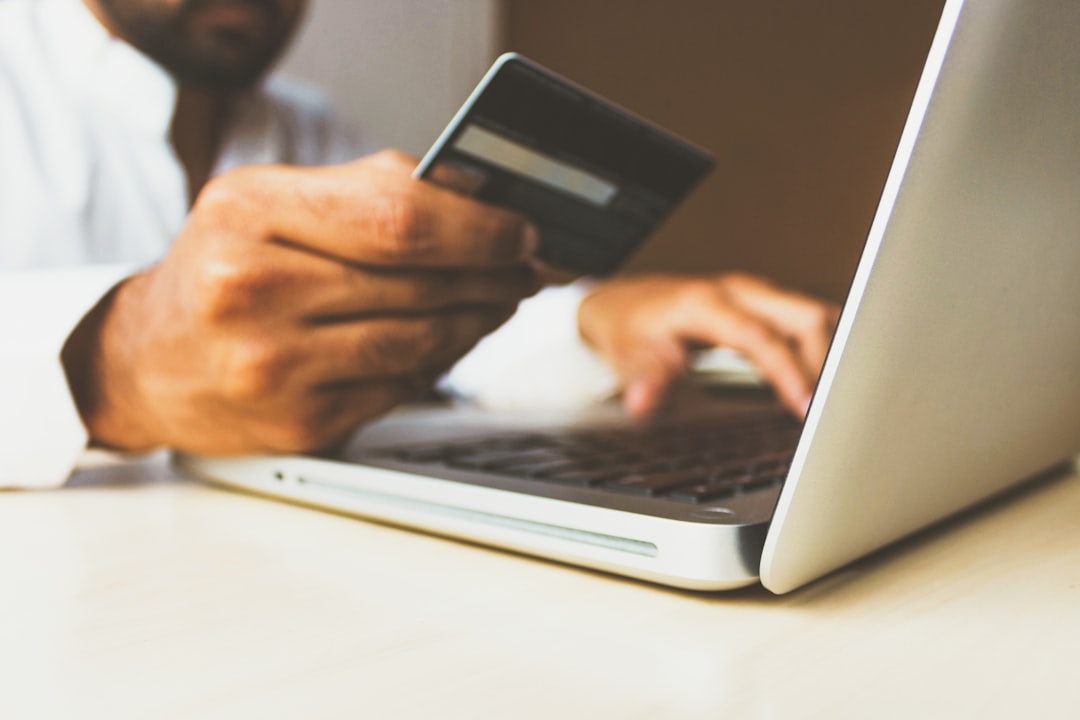 Business owner making an online payment with a laptop and card