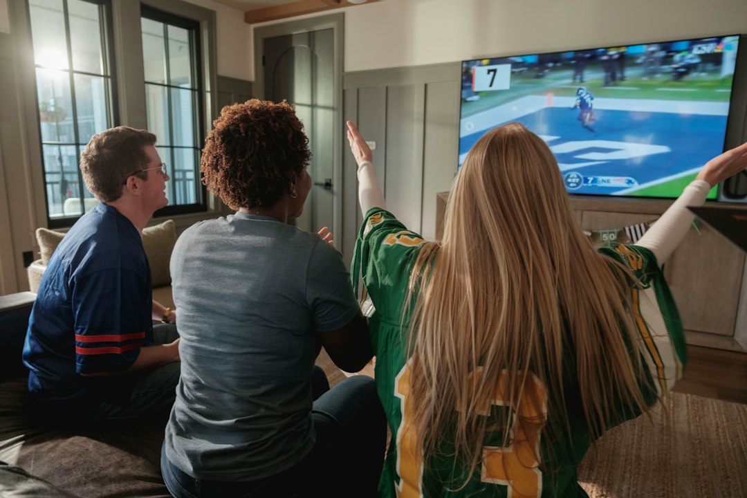 Friends watching a sports game on television at home